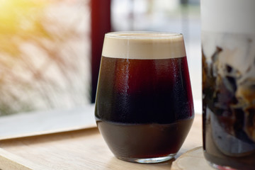 Iced black coffee on wooden plate.