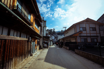 Naklejka na ściany i meble Miyajima, Japan - January 02, 2020: Cityscape to the Walking Tourists and Itsukushima streets