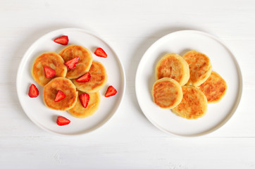 Cottage cheese pancakes with strawberry, syrniki on white background