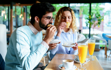 Couple sitting in a cafe, having breakfast. Love, dating, food, lifestyle concept