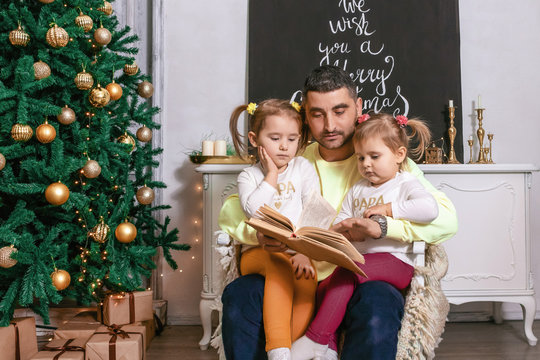 friendly family reading a book at Christmas photo