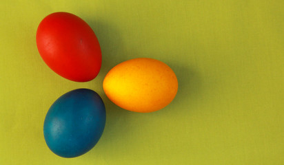 Primary colors Easter eggs green background