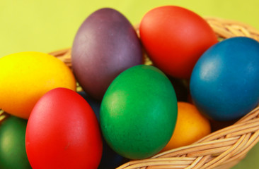 Obraz na płótnie Canvas Easter eggs colors in basket green background