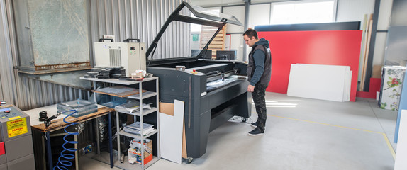 Technician works on Laser CNC computer numerical control cutting machine
