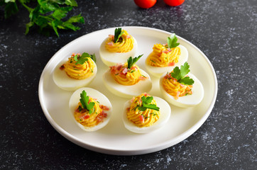 Stuffed eggs with egg yolk, bacon, mustard and parsley