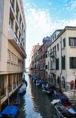 A typical alley of the old part of the island of Venice. The narrow channel between colorful historic houses. The romantic city, a place for tourists.