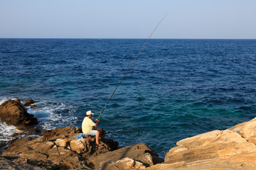 Naxos Town, Naxos / Greece - August 23, 2014: A fisherman in Naxos island, Naxos Town, Naxos, Cyclades Islands, Greece