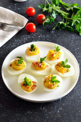 Stuffed eggs with egg yolk, bacon, mustard and parsley