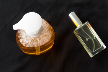 Bottle of liquid soap with a pump . perfume bottle on black background
