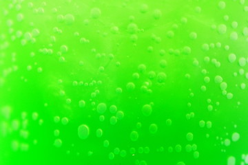 Closeup of beautiful bubbles in a clear glass with bright green juice inside for cold drink booster after work out or sun exposure outdoor. Food and drink preparing concept