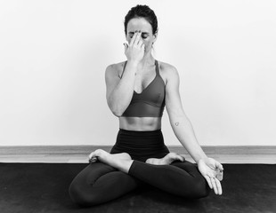 Unsaturated photography of a woman meditating and doing the Pranayama anuloma viloma yoga position