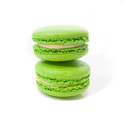 two bright green macaroons one on top of the other on a white isolated background