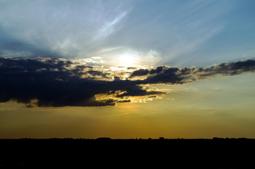 in the sky a large black cloud covering the sun above the city