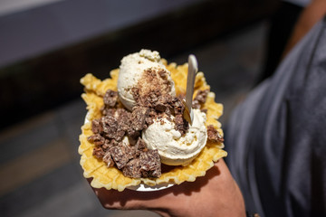 Rolled ice cream with chocolate crumble in a waffle bowl