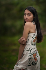 young woman with dress in the middle of nature looking at the camera