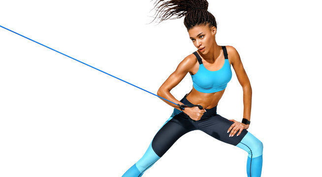 Strong girl working with resistance band. Photo of african american girl in fashionable sportswear on white background. Dynamic movement. Sports and healthy lifestyle