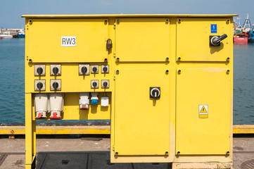 Yellow power supply switch box in the harbor