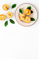 Healthy food. Ripe sliced peaches on plate on white table top-down copy space
