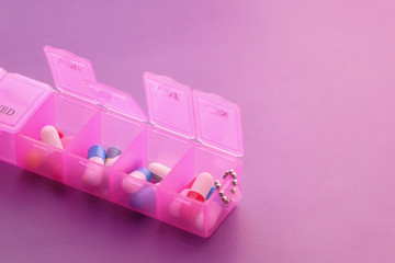 Close up of pink color pills in a pill box 