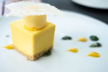 Lemon cheescake in cube form - droplets of garnish - delicious