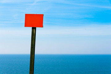 Blank warning signage near sea coast cliff