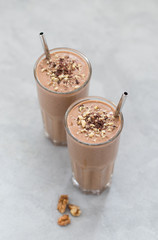 Smoothies of dates, nuts, chocolate with almond milk in a glass on a light background