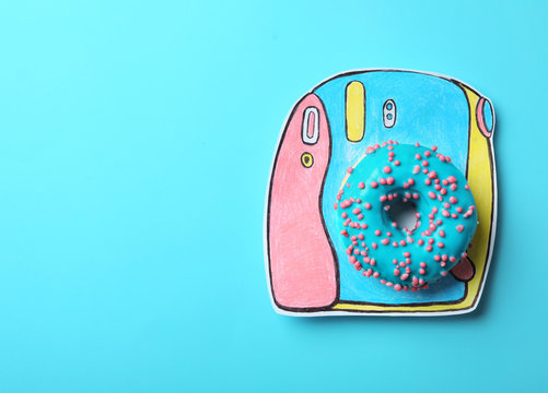 Camera made with donut on light blue background, top view. Space for text