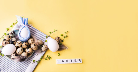 Overquail eggs with young sprigs of green plants on a light background.