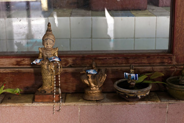 Figurines of gods with offerings in a Buddhist temple, Myanmar