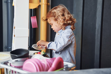 Child in casual clothes have fun by learning how to prepare food