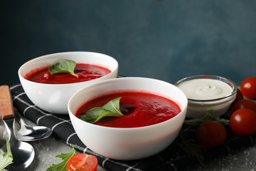 Tomato cream soup on grey table, space for text