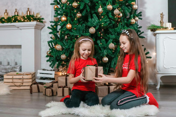 Obraz na płótnie Canvas happy girl opening Christmas presents at home photo