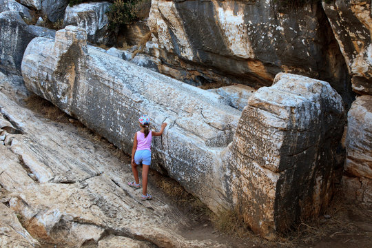 Naxos / Greece - August 25, 2014: Tourist near Giant male statue called Kouros, Naxos, Cyclades Islands, Greece