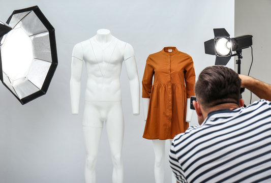 Professional photographer taking picture of ghost mannequin with stylish clothes in modern photo
