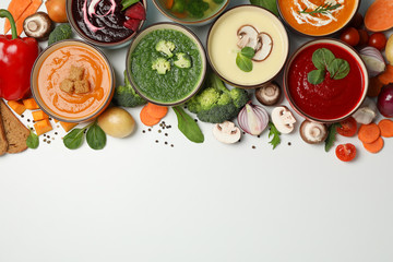 Vegetable soups and ingredients on white background, space for text