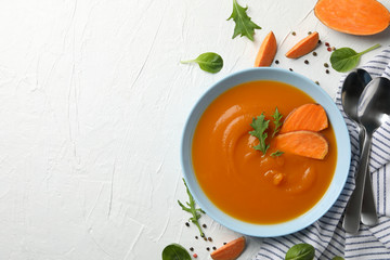Sweet potato cream soup on white background, top view