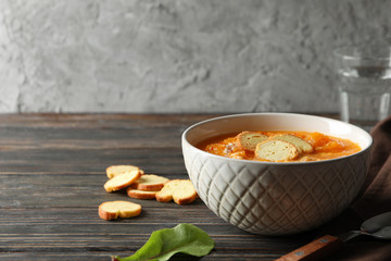 Pumpkin cream soup with croutons on wooden background, space for text