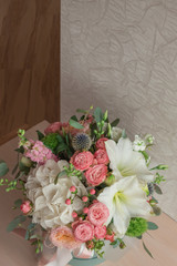 A large flower arrangement in a hat box was created by a florist for a wedding gift. Hydrangea, amarallis, roses and eucalyptus in a bouquet