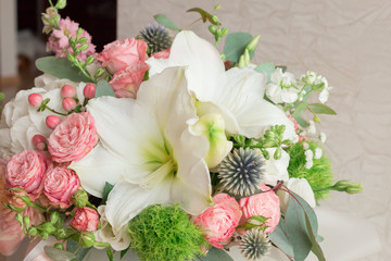 A large flower arrangement in a hat box was created by a florist for a wedding gift. Hydrangea, amarallis, roses and eucalyptus in a bouquet