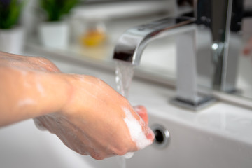 Obraz na płótnie Canvas woman washing her hands in the bathroom