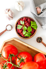 Homemade tomato sause near ingredients - garlic, spices - on white background top-down