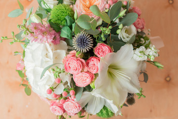 A large flower arrangement in a hat box was created by a florist for a wedding gift. Hydrangea, amarallis, roses and eucalyptus in a bouquet