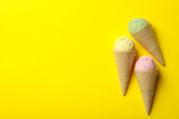 Ice cream in waffle on yellow background, space for text