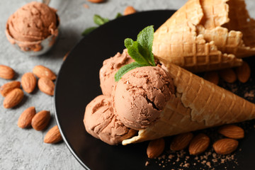Ice cream, waffles and almond on grey table, close up