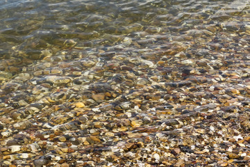 Flußkiesel im Wasser glitzern in der Sonne
