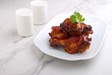 Baked chicken wings in soy sauce and honey, on a marble background