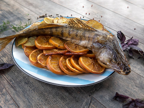 Delicious dish of seafood. delicious roasted fish with orange slices.
