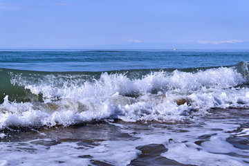 Fototapeta premium Waves with foam close up on a tropical sandy beach. Copy space for background