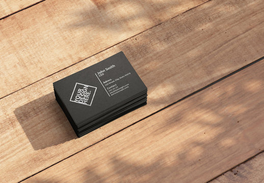 Stack of Black Business Cards Mockup on Brown Wooden Table Outdoors