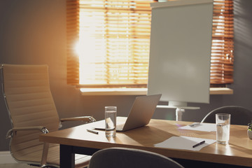 Laptop on wooden table in modern office